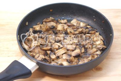 Сковороду вымыть, добавить масло и ломтиками порезанные грибы шампиньоны, обжарить 2-3 минуты и немного посолить