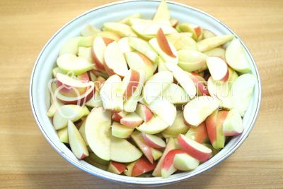Нарезать яблоки дольками, удаляя сердцевину.