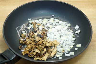Мелко нашинкованный лук и мелко нарезанные (отжатые) грибы обжарить на сковороде с растительным маслом.