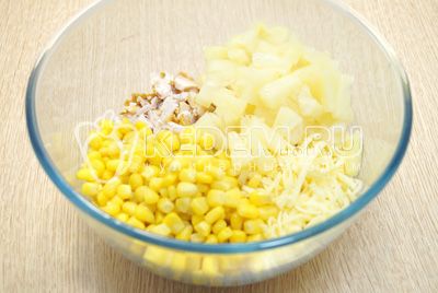 Добавить консервированную кукурузу и кубиками нарезанные ананасы.