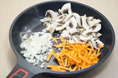 На сковороде обжарить с растительным маслом мелко нашинкованный лук, соломкой нарезанную морковь и нарзанные грибы.