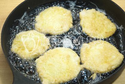 На сковороде разогреть растительное масло, обмакнуть ломтик кабачка в кляр и жарить на сковороде с двух сторон.