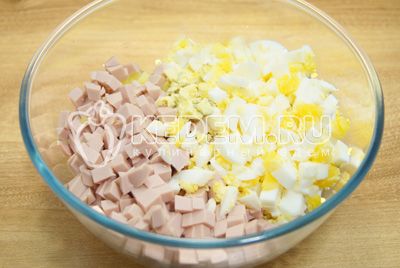 Нарезать кубиками в миску овощи. Добавить кубиками нарезанную вареную колбасу и яйца.