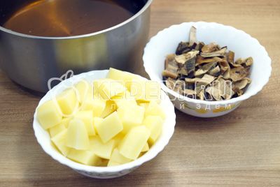 Грибы вынуть и нарезать, картофель очистить и нарезать кубиками, в настой от грибов добавить еще 1 литр воды и поставить варить вместе с картофелем и грибами.