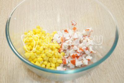 В миску нарезать кубиками крабовые палочки, добавить консервированную кукурузу.
