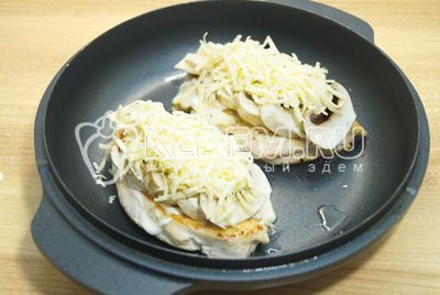 Сбрызнуть грибы растительным маслом и посыпать тертым сыром.