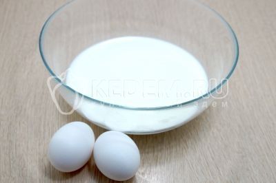 В миску влить 500 мл молока и разбить 2 яйца.