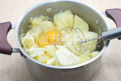 Воду слить с картофеля, добавить 2 яйца и 100 г сливочного масла. Хорошо примять толкушкой.