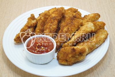 Кусочки куриного филе выложить на блюдо и подавать с кетчупом или томатным соусом.