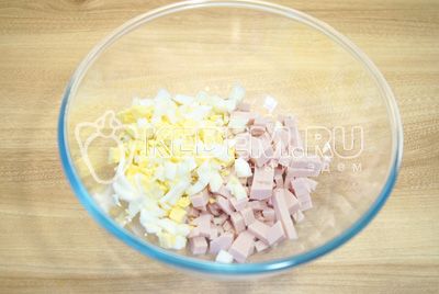 В миску нарезать кубиками колбасу и яйца.