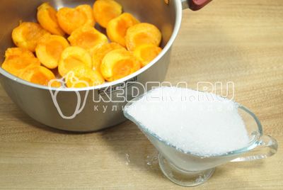 Выкладывать в кастрюлю для варки слоями, чередуя абрикосы с сахаром.